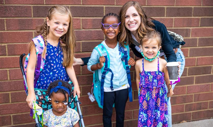 A family of five smiles on the first full day of kindergarten